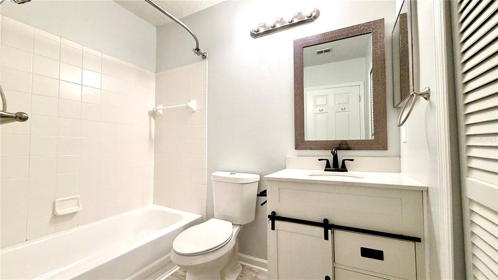 4332 South Kirkman Road, Unit 1012 Orlando, FL 32811 - Photo 11 of 20 a bathroom with a sink toilet vanity and shower