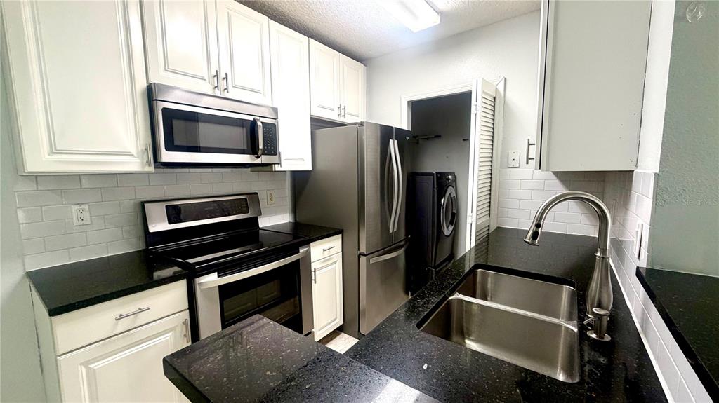 4332 South Kirkman Road, Unit 1012 Orlando, FL 32811 - Photo 4 of 20 a kitchen with a refrigerator stove and microwave
