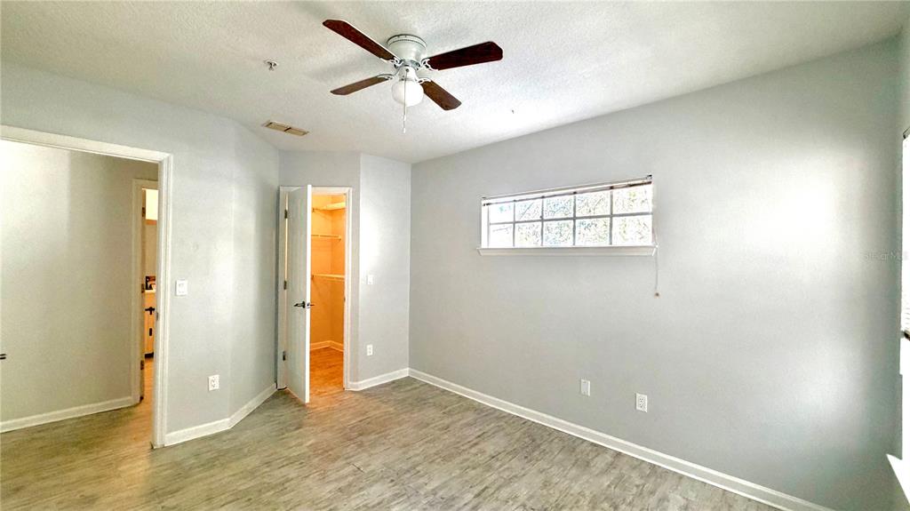 4332 South Kirkman Road, Unit 1012 Orlando, FL 32811 - Photo 6 of 20 wooden floor in an empty room with a window