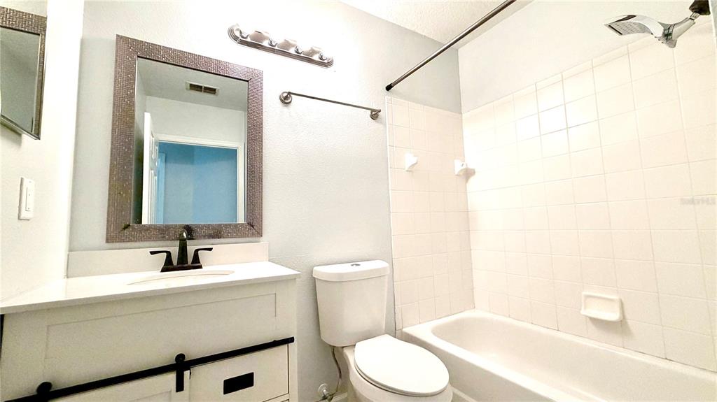 4332 South Kirkman Road, Unit 1012 Orlando, FL 32811 - Photo 9 of 20 a bathroom with a sink a toilet and shower