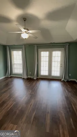 a view of empty room with wooden floor and window