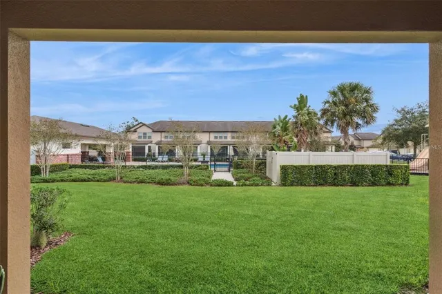 a view of a fountain in front of a house with a big yard