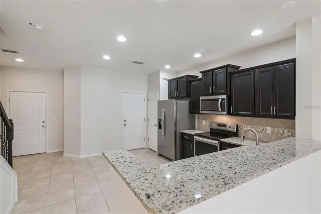 a kitchen with stainless steel appliances granite countertop a refrigerator and a sink