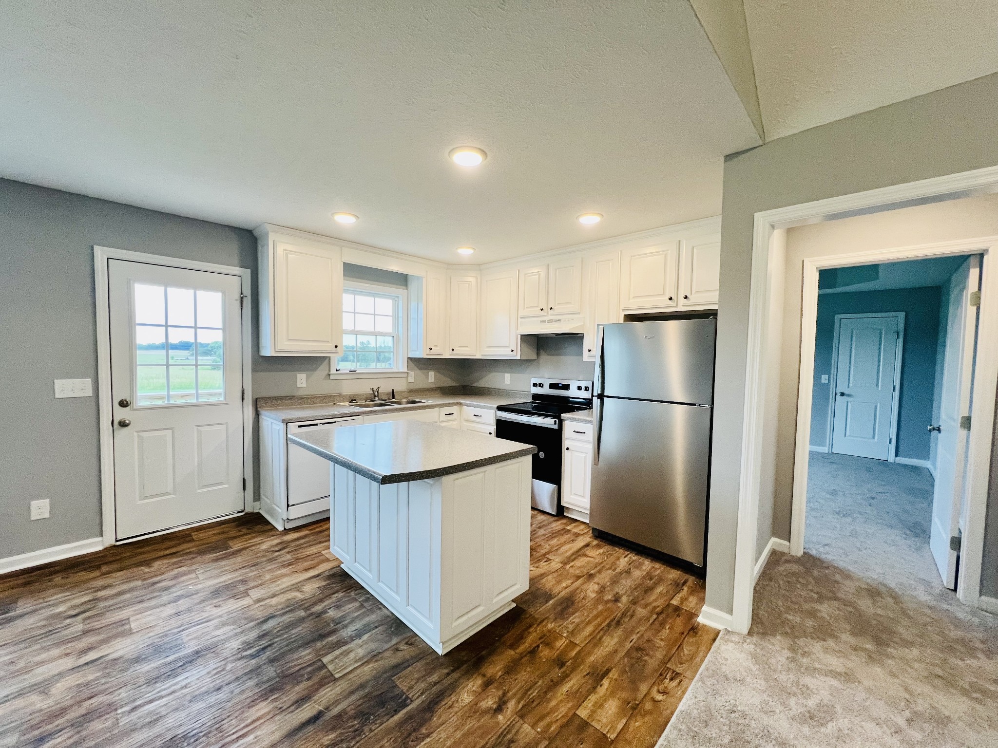 466 White Road Pulaski, TN 38478 - Photo 4 of 25 a kitchen with a refrigerator a sink and dishwasher with wooden floor