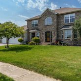 a front view of a house with a yard and trees
