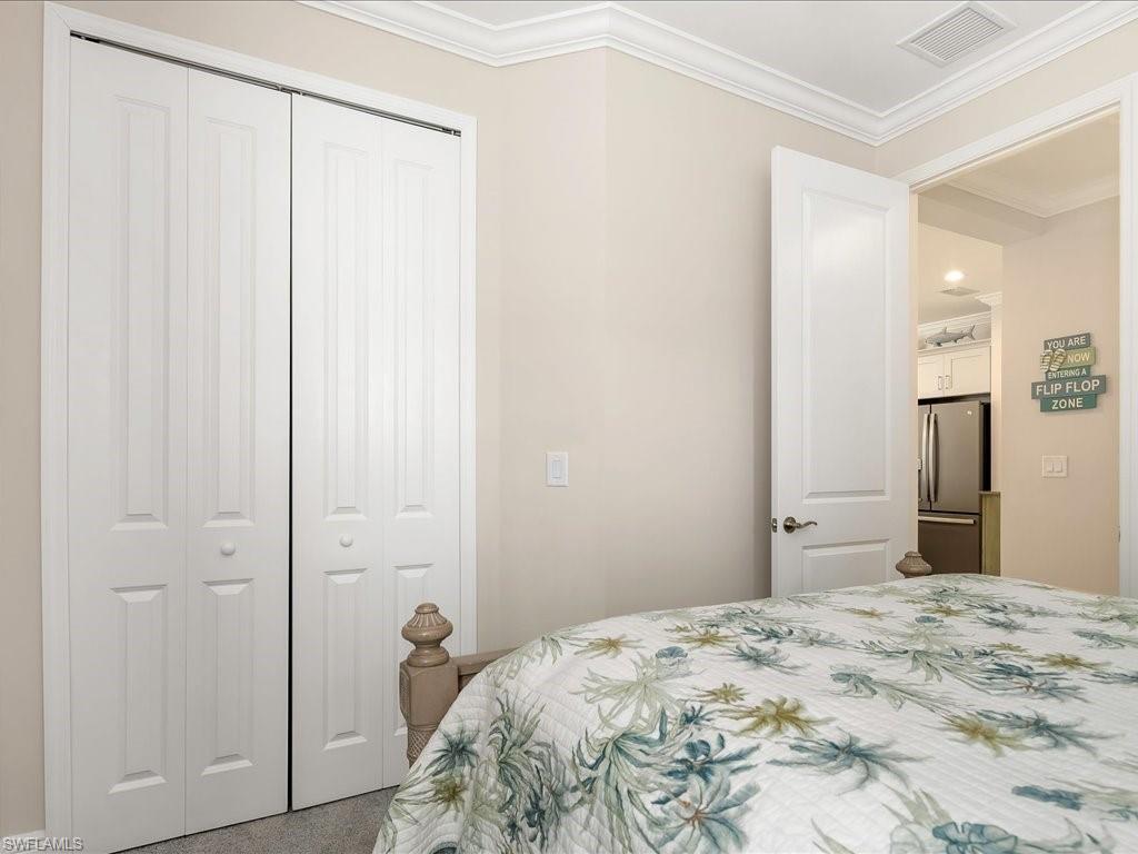 2227 Marquesa Circle Naples, FL 34112 - Photo 12 of 26 a bedroom with a bed and wooden floor