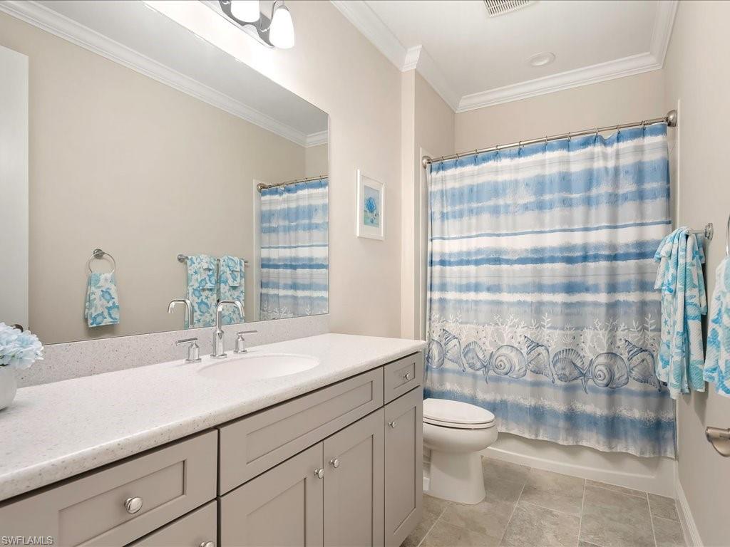 2227 Marquesa Circle Naples, FL 34112 - Photo 10 of 26 a bathroom with a sink a toilet and shower curtain