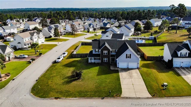 an aerial view of a house with swimming pool and lake view