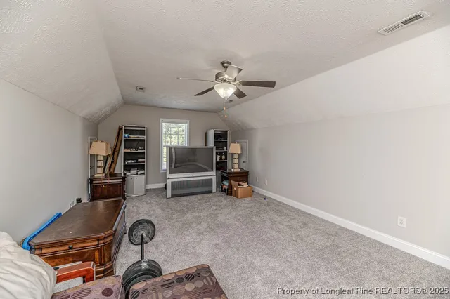 a living room with furniture a piano and a bookshelf