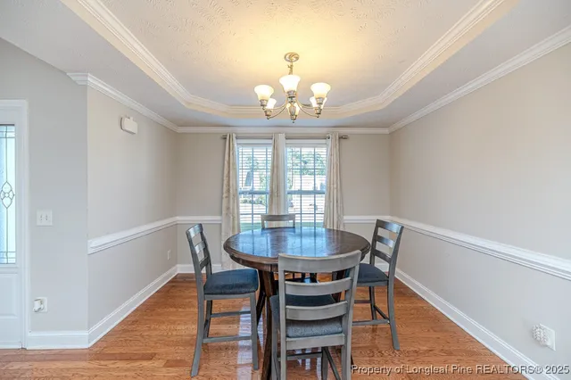 a view of a dining room with furniture a chandelier and wooden floor