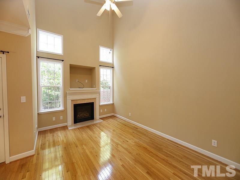 5947 Four Townes Lane Raleigh, NC 27616 - Photo 5 of 12 an empty room with a fireplace and windows