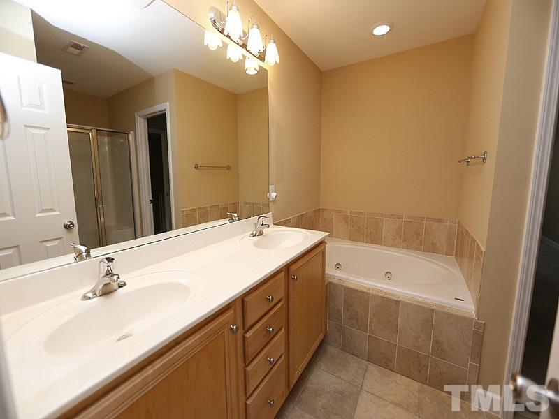 5947 Four Townes Lane Raleigh, NC 27616 - Photo 8 of 12 a bathroom with a sink double vanity granite tub shower and a mirror