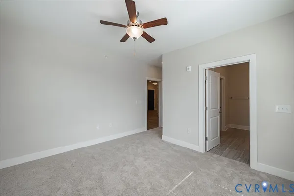 an empty room with closet and fan