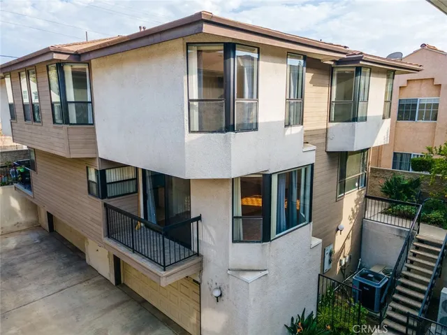 an aerial view of residential houses with outdoor space and trees