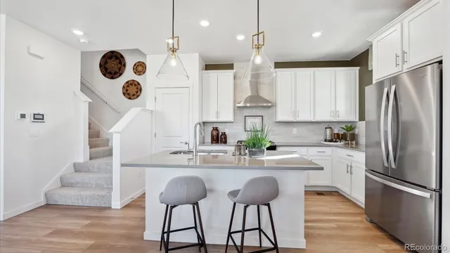a kitchen with stainless steel appliances granite countertop a sink a stove and a refrigerator