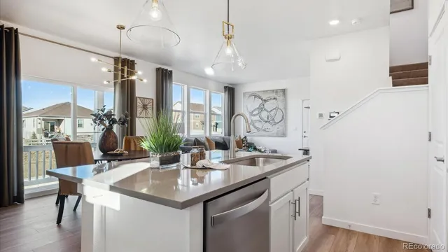 a kitchen with a sink a counter space and wooden floor
