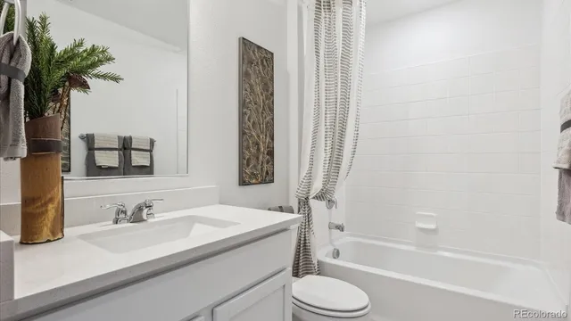 a bathroom with a granite countertop sink toilet a mirror a bathtub and shower