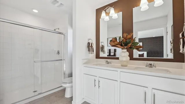 a bathroom with a double vanity sink mirror and toilet