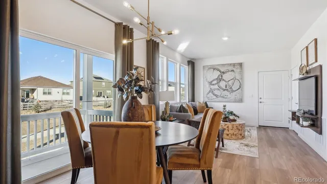 a dining room with furniture a chandelier and wooden floor