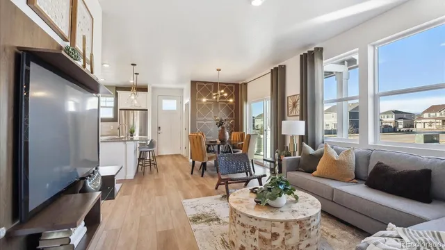 a living room with furniture wooden floor and a large window