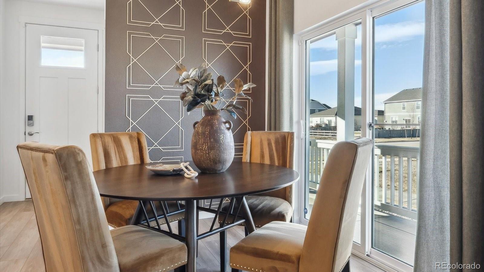 906 Logan Peak Way Berthoud, CO 80513 - Photo 6 of 29 a dining room with furniture and wooden floor
