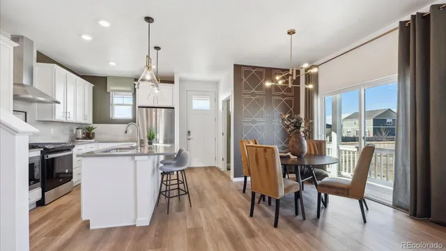 a view of a dining room and livingroom with furniture wooden floor a chandelier
