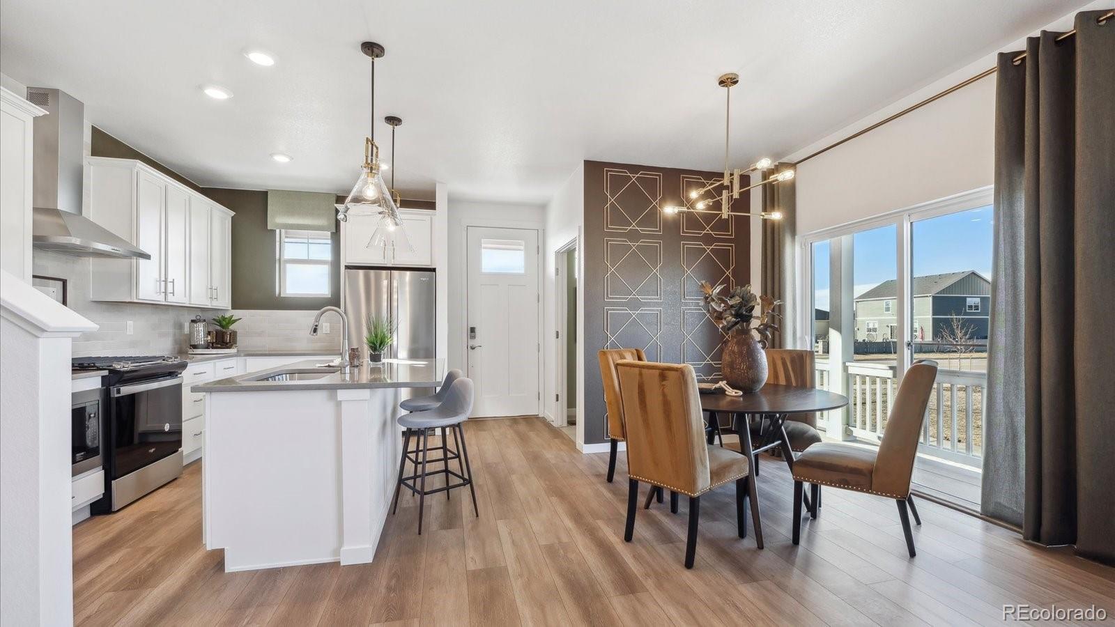 906 Logan Peak Way Berthoud, CO 80513 - Photo 7 of 29 a view of a dining room and livingroom with furniture wooden floor a chandelier