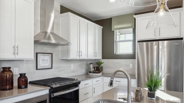a kitchen with stainless steel appliances granite countertop a sink stove and white cabinets