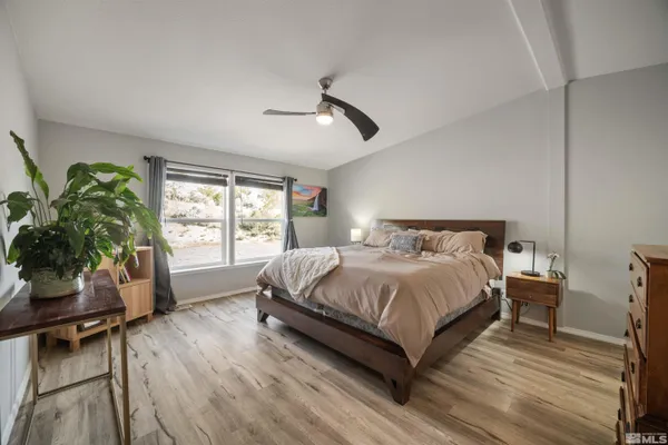 a bedroom with a bed window and potted plant on table
