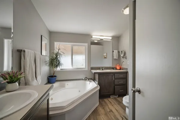 a spacious bathroom with a tub sink and mirror