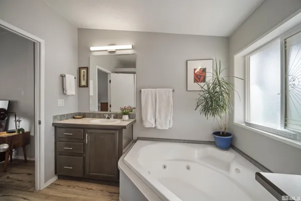 a bathroom with a tub sink and mirror