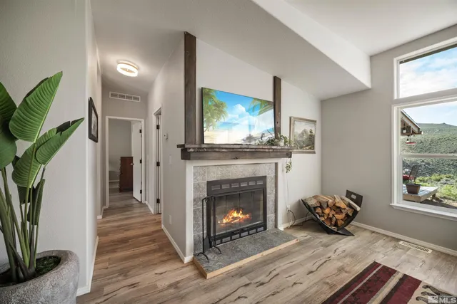 a living room with furniture large window and flat screen tv
