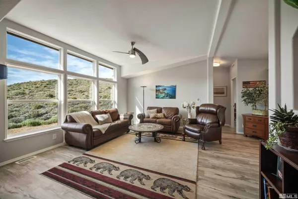 a living room with furniture large window and flat screen tv