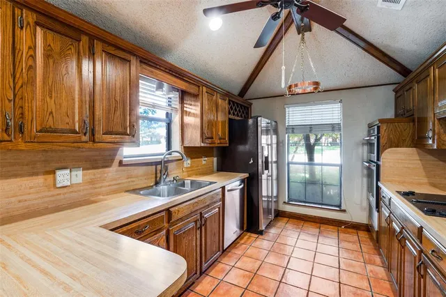 a kitchen with stainless steel appliances granite countertop a sink stove and cabinets