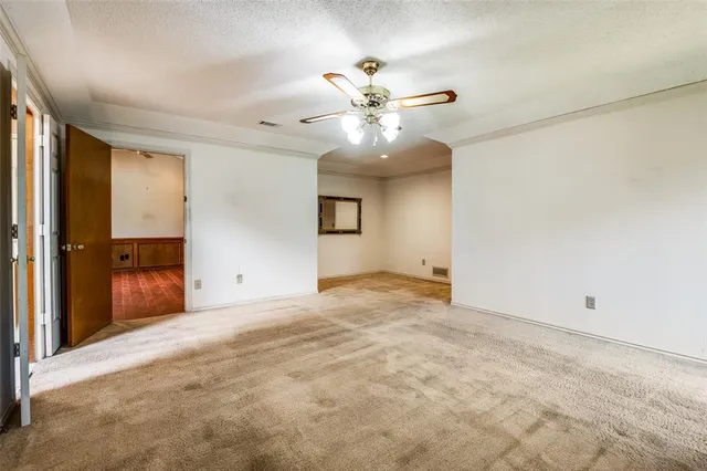 an empty room with closet and a chandelier fan