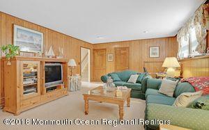 18 Dale Road Middletown, NJ 07748 - Photo 26 of 48 a living room with furniture a flat screen tv and a floor to ceiling window