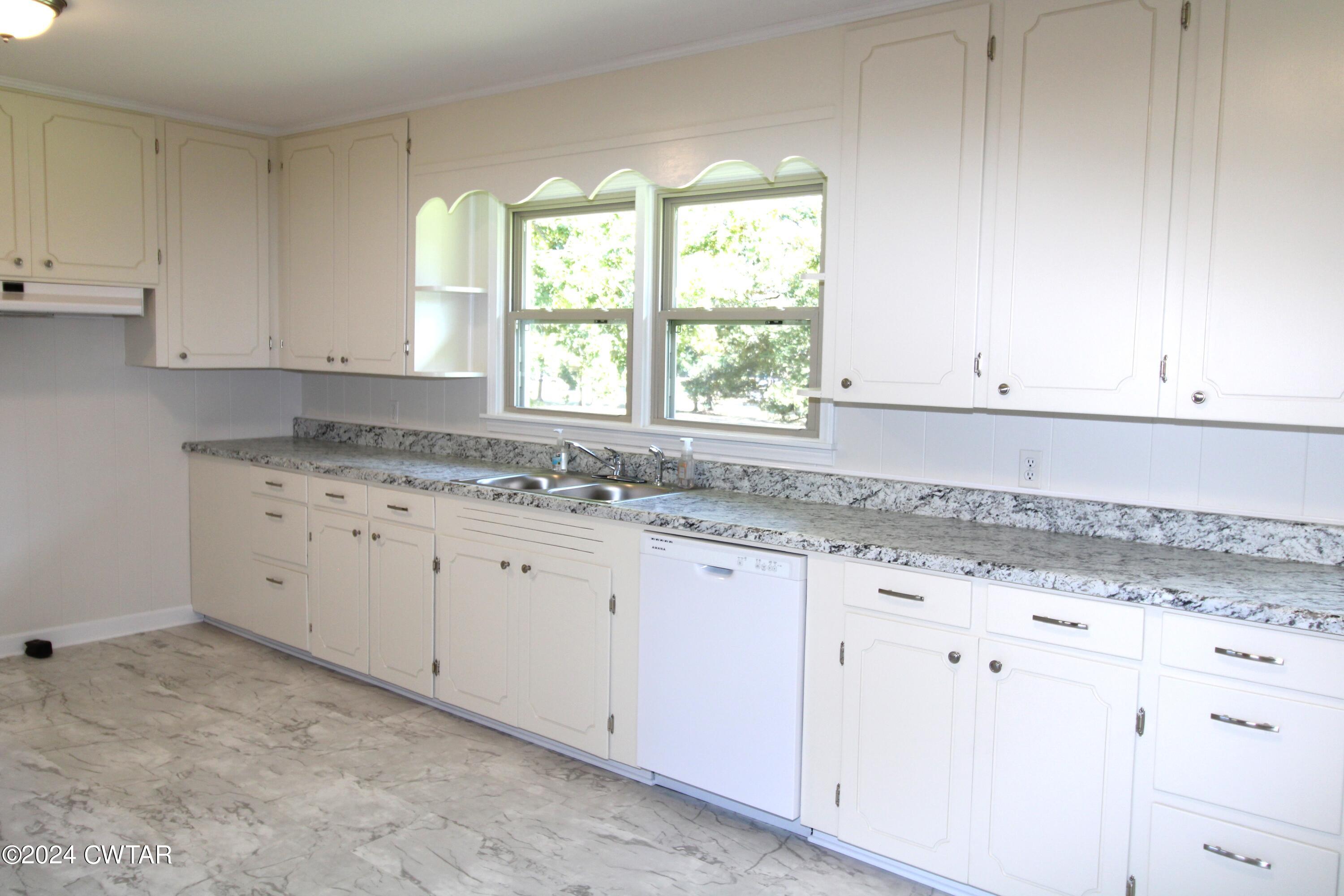 465 Crucifer Road Huron, TN 38345 - Photo 5 of 15 a kitchen with granite countertop white cabinets and a sink