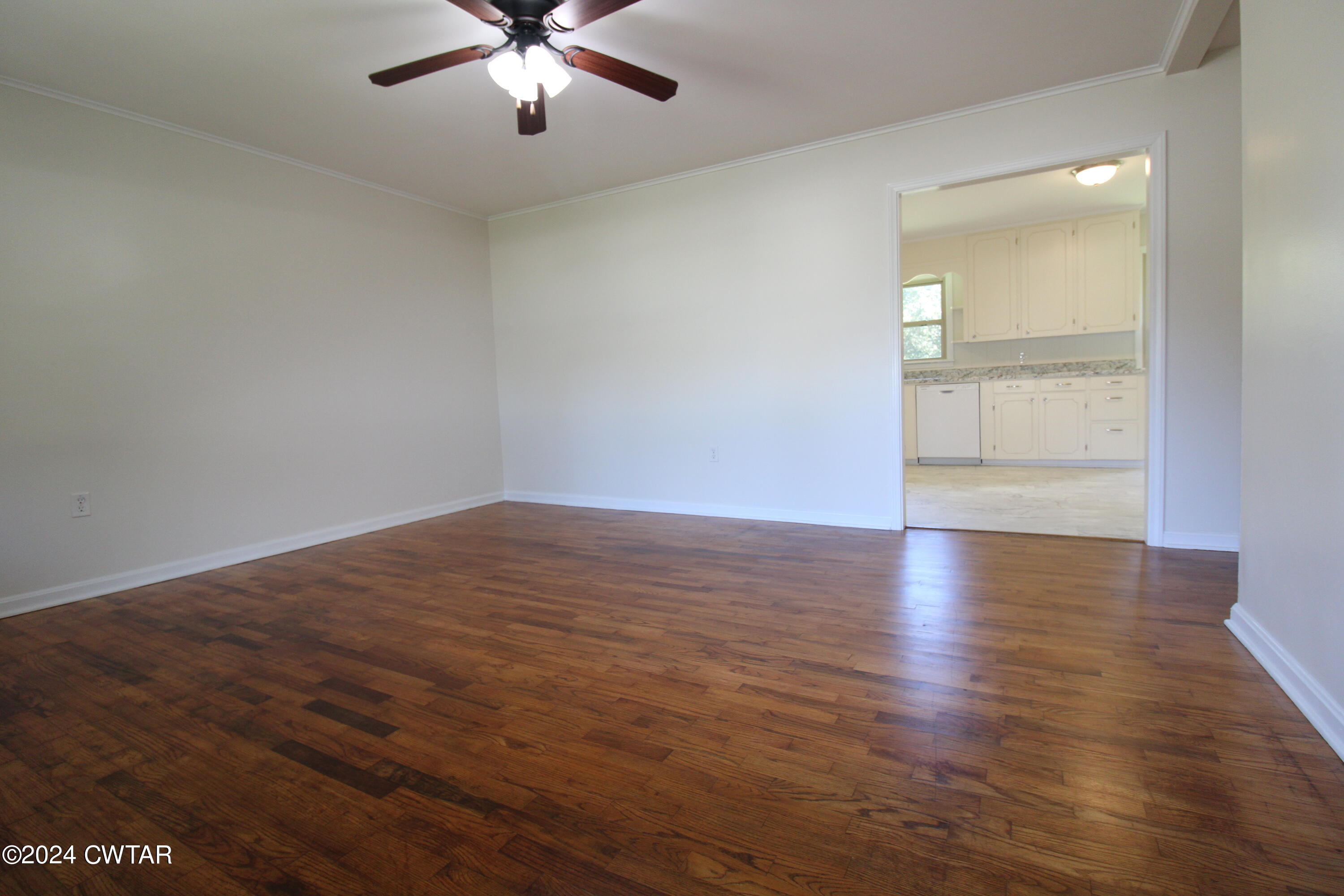 465 Crucifer Road Huron, TN 38345 - Photo 8 of 15 an empty room with wooden floor and windows
