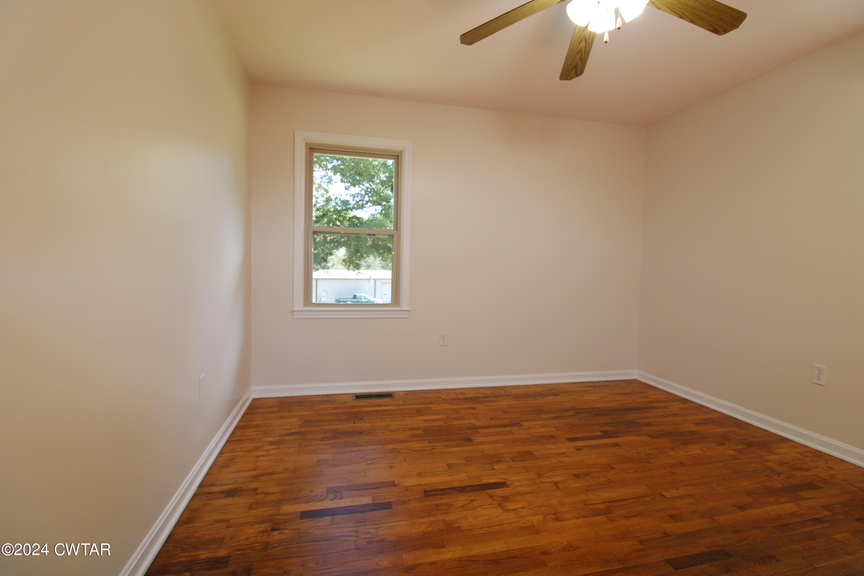 465 Crucifer Road Huron, TN 38345 - Photo 9 of 15 an empty room with a chandelier fan and windows