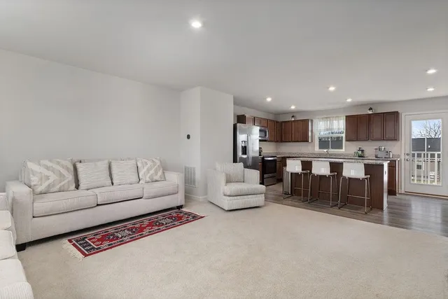 a living room with furniture and kitchen view