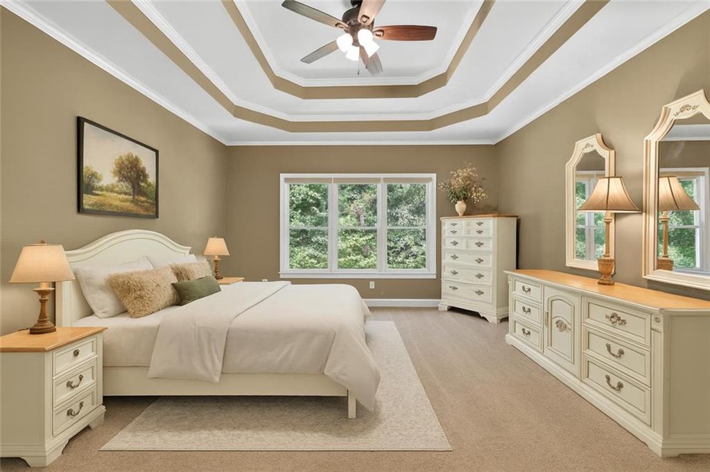 994 Fairview Club Circle Dacula, GA 30019 - Photo 14 of 57 a spacious bedroom with a bed a window and a chandelier