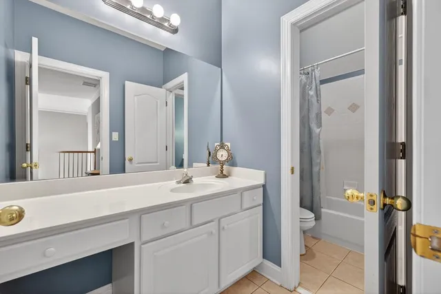 a bathroom with a granite countertop sink a toilet and shower