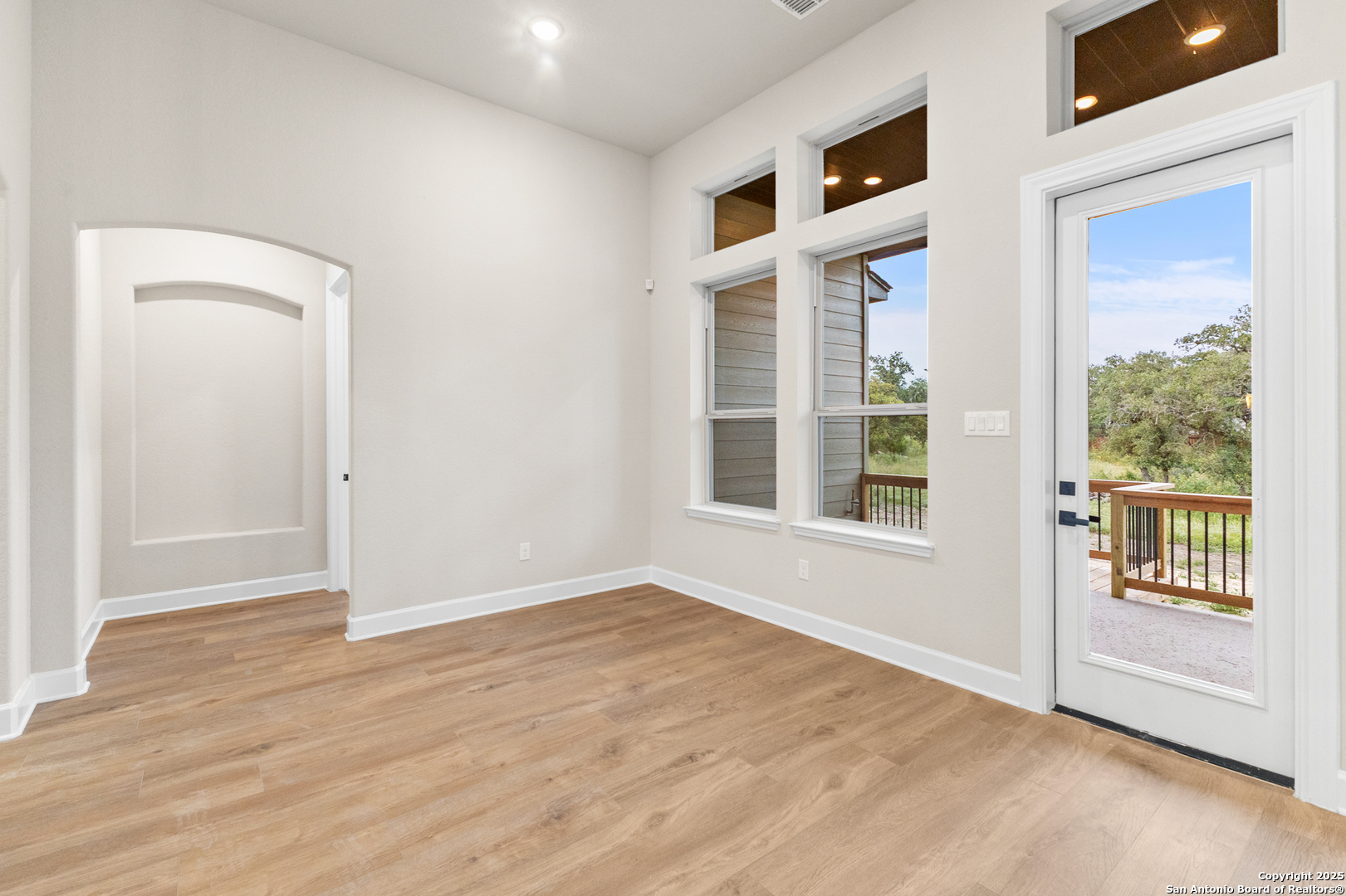 399 James Way Castroville, TX 78009 - Photo 17 of 32 an empty room with wooden floor and windows