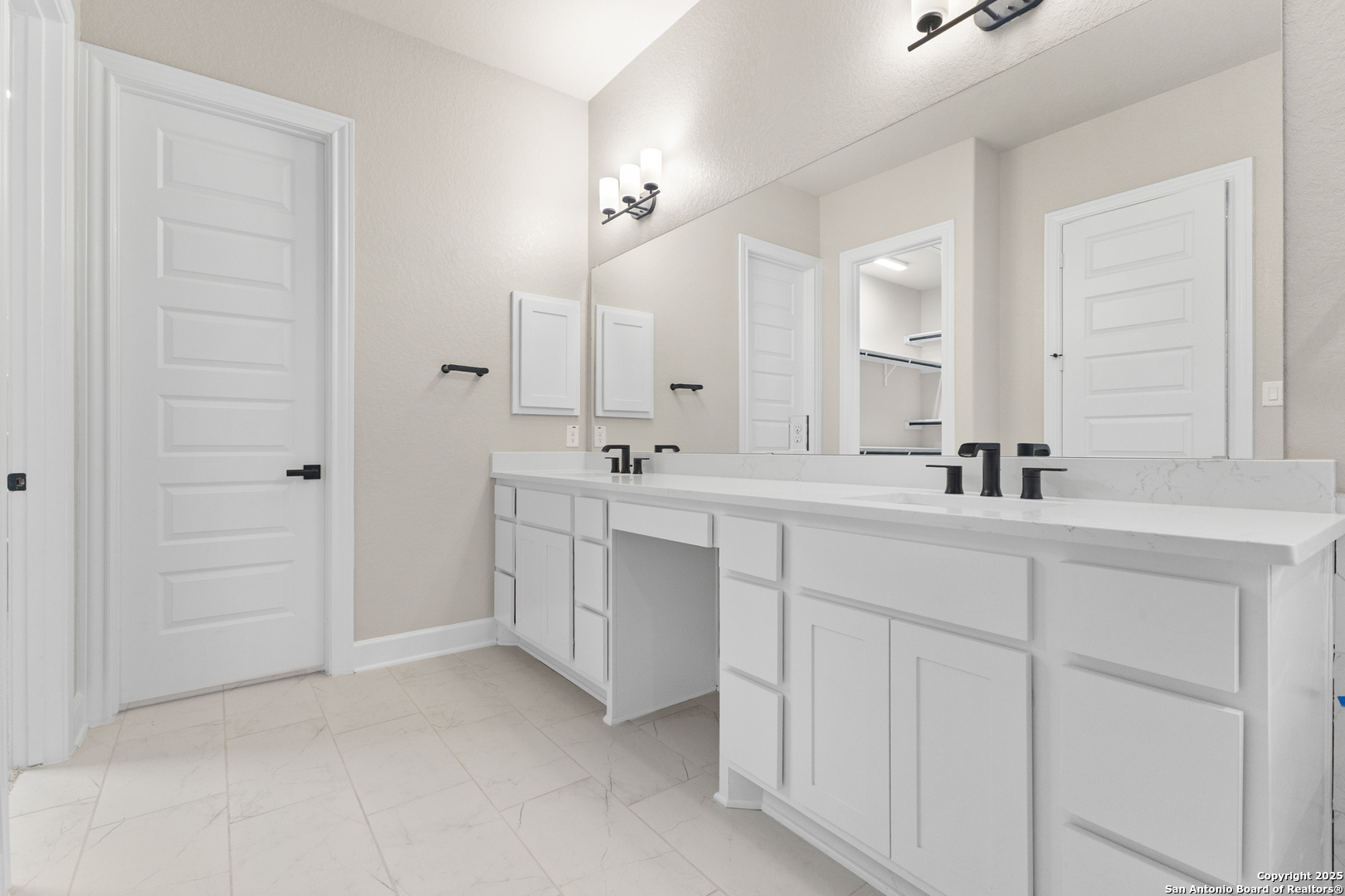 399 James Way Castroville, TX 78009 - Photo 21 of 32 a bathroom with a double vanity sink a mirror and a shower