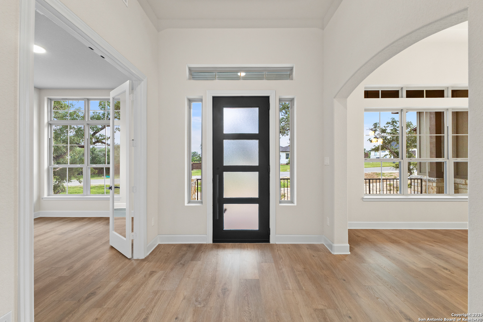 399 James Way Castroville, TX 78009 - Photo 4 of 32 an empty room with wooden floor and windows