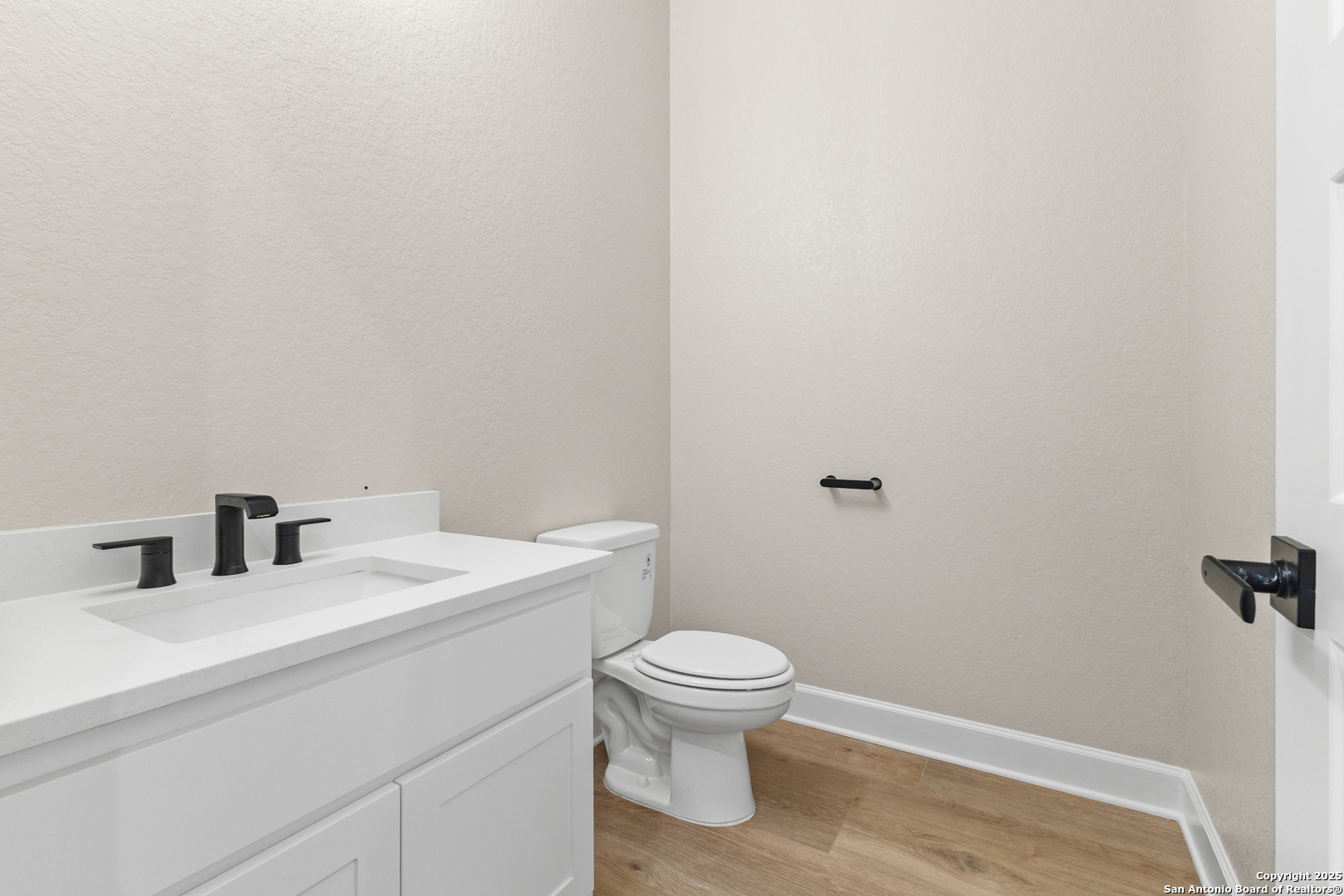 399 James Way Castroville, TX 78009 - Photo 8 of 32 a bathroom with a sink a toilet and a mirror