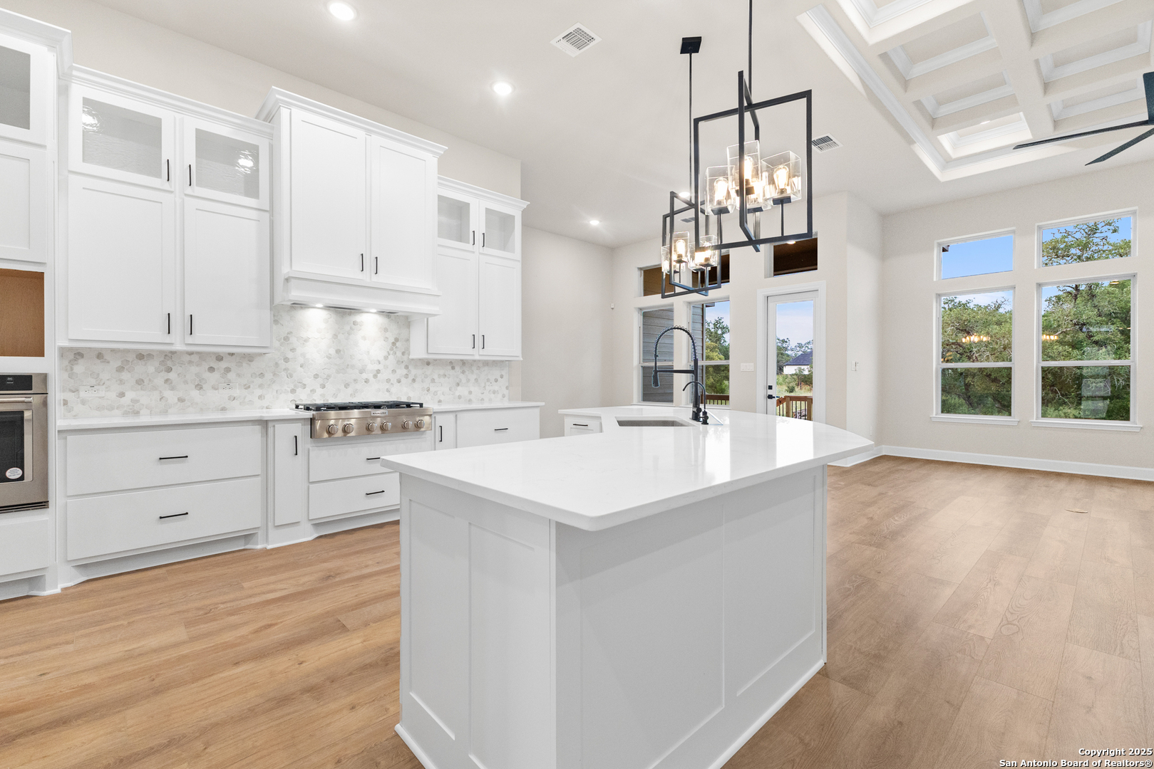 399 James Way Castroville, TX 78009 - Photo 9 of 32 a kitchen with stainless steel appliances kitchen island hardwood floor sink and stove