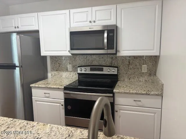 a kitchen with stainless steel appliances granite countertop a stove microwave and refrigerator