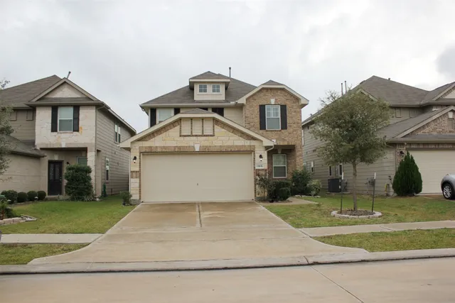 a front view of a house with a yard and garage