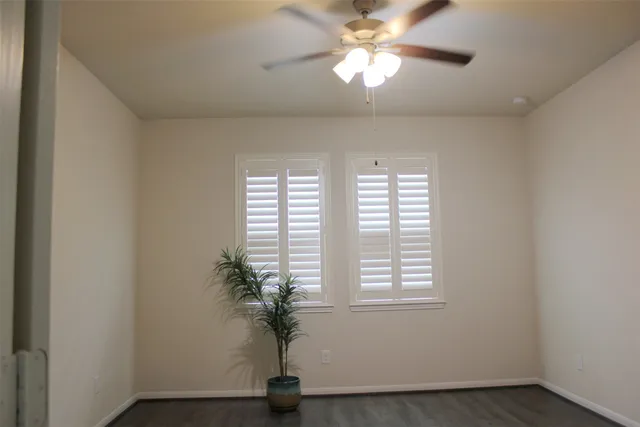 an empty room with a window and a ceiling fan